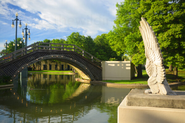 Lighted Bridge Reflects Over The Waterway Of Louis Armstrong Park In New Orleans, Louisiana