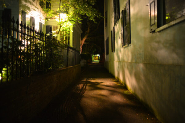 Distant Double Doors Down The Dark Night Time Alley In The Historic District Of Charleston, South Carolina