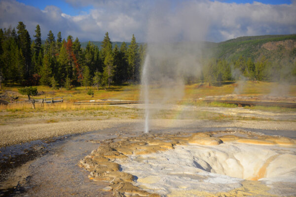 An Ultra Rare Eruption Of Uncertain Geyser Produces A Rainbow Over A Deep Drain Of Sawmill Geyser In Yellowstone National Park, Wyoming