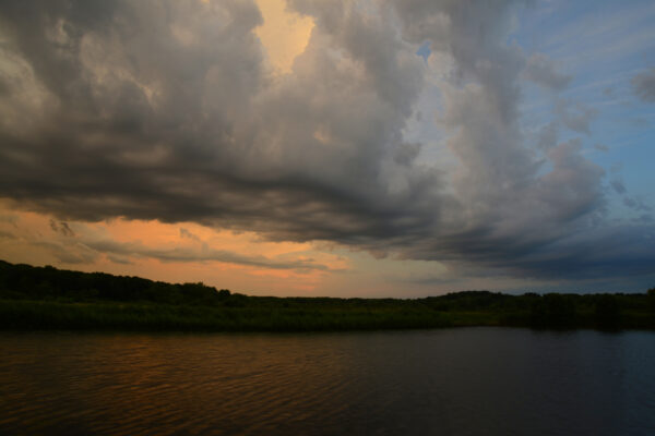 A Very Elongated Cloud Formation Stretches Clear Across The Horizons As The Sun Sets Over The Wetland Wilderness Of Wisconsin